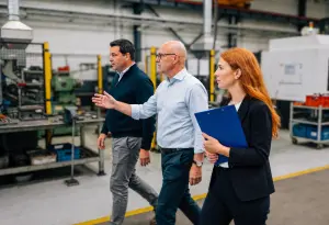 Drie medewerkers krijgen rondleiding in de fabriek